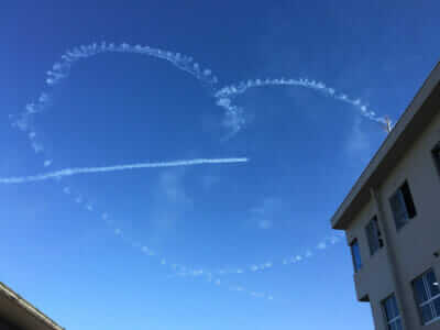 飛行機雲でハートを描きながら飛ぶブルーインパルス